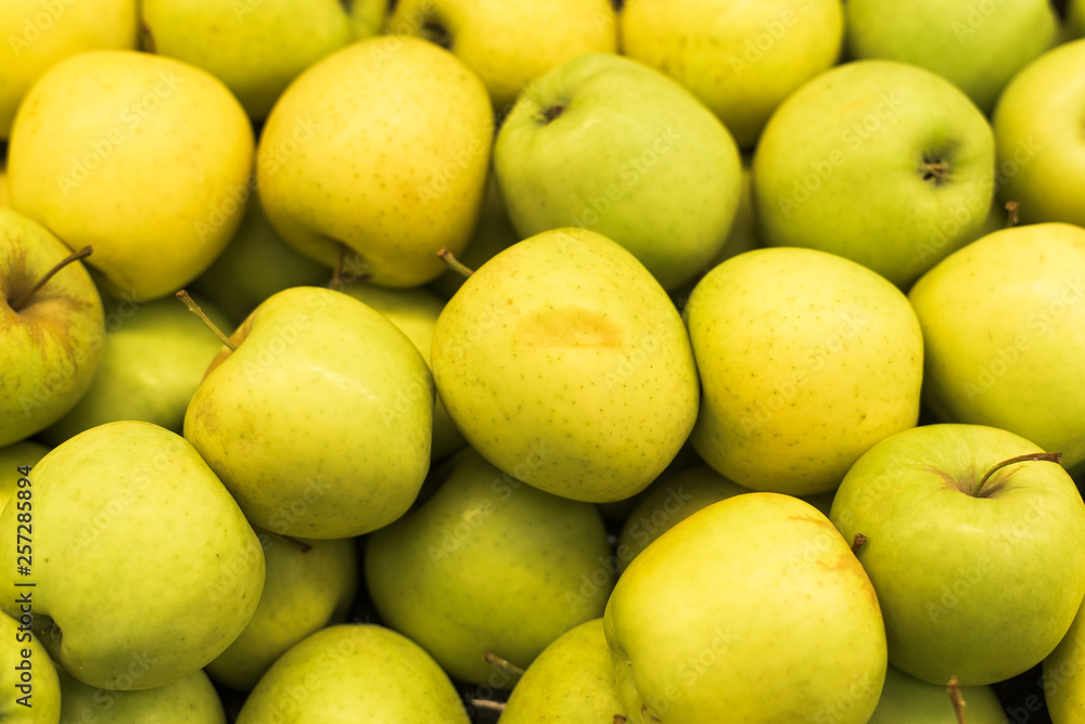 A large number of apples in the supermarket. Many green apples in a palette A large number of apples in the supermarket. Many green apples in a palette