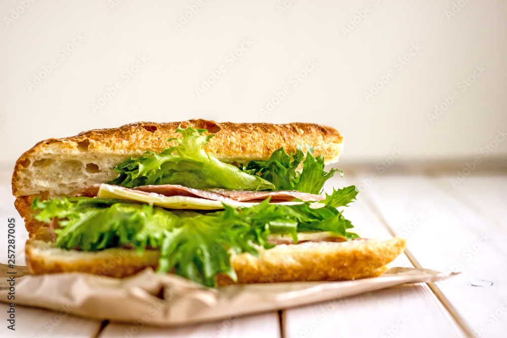 Closed sandwich with greens, ham and cheese. Close-up, copy space Closed sandwich with greens, ham and cheese. Close-up, copy space