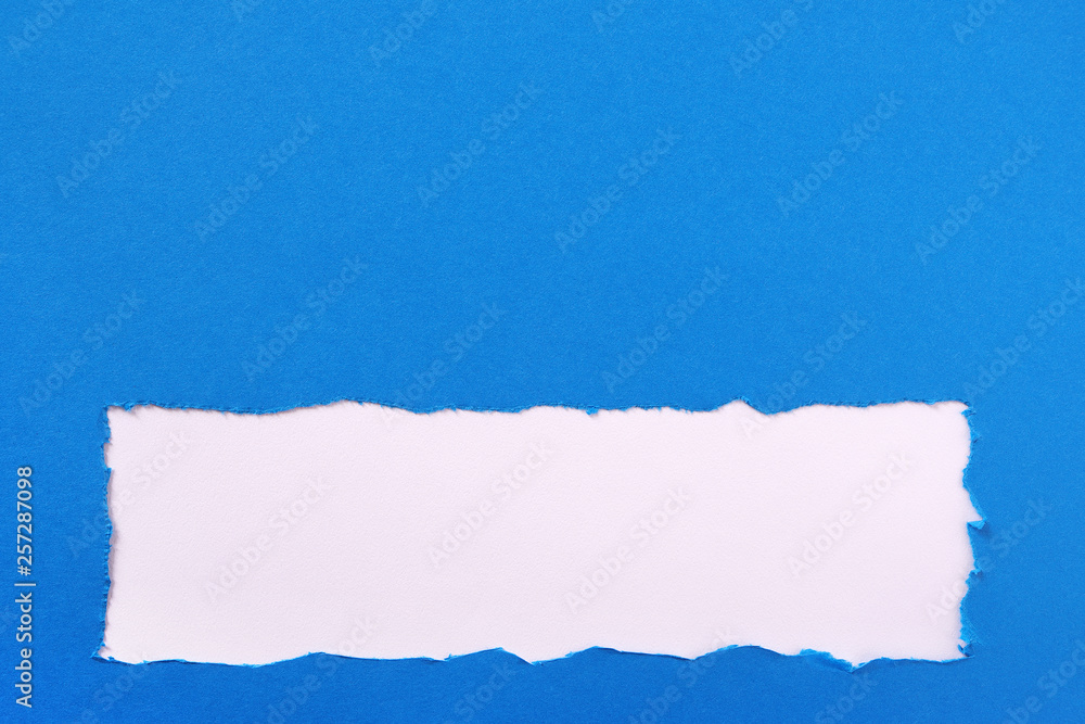 Fototapeta premium Torn blue paper strip ragged edge border frame