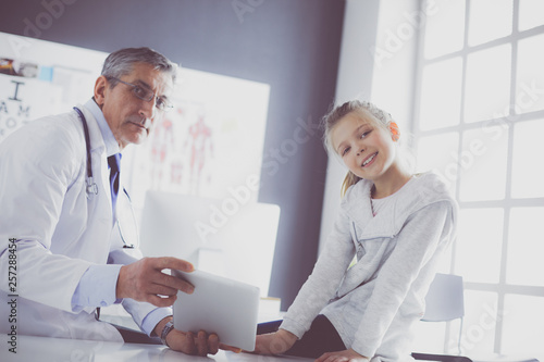 Portrait of a cute little girl and her doctor at hospital