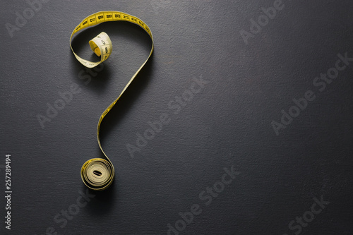 Obraz na płótnie Tape measure forming the shape of question mark on chalkboard w salonie