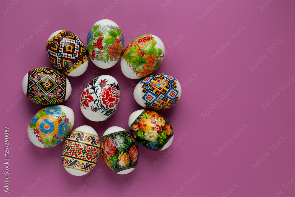 Colorful paschal eggs of traditional motifs on pink background. Festive paschal card with сopy space. Easter tradition 