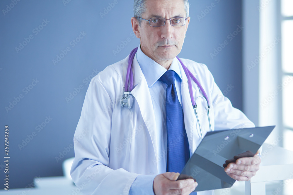 Male doctor writes notes on the clipboard in the hospital Male doctor writes notes on the clipboard in the hospital