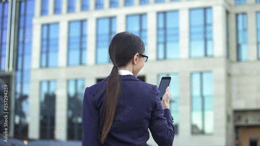 Female office worker reading message on smartphone outdoors, social network app Female office worker reading message on smartphone outdoors, social network app
