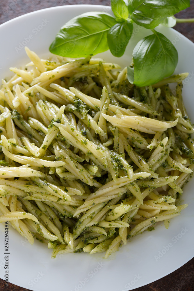 Traditional trofie pasta with pesto sauce on white plate Traditional trofie pasta with pesto sauce on white plate