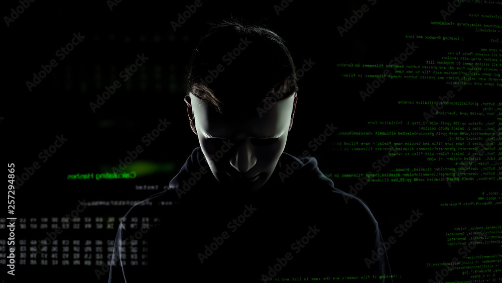 Scary hacker in white mask attacking personal data, codes and numbers background Scary hacker in white mask attacking personal data, codes and numbers background