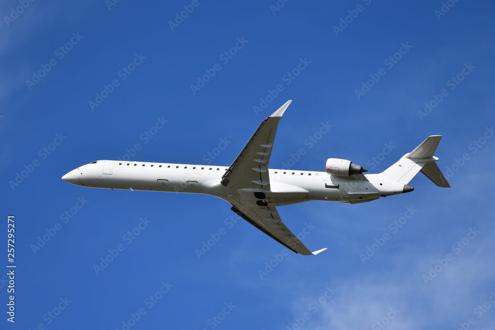 White airplane flying, blue sky in background White airplane flying, blue sky in background
