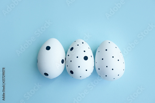 Three Easter eggs on blue background. Happy Easter card