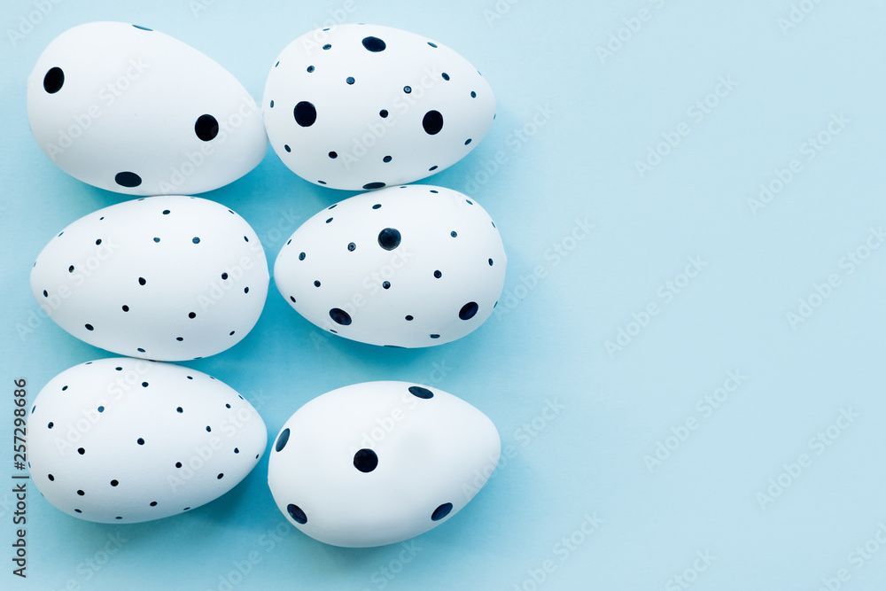 Easter holiday creative background with white Easter eggs and copy space on blue background. Flat lay, top view. Easter concept Easter holiday creative background with white Easter eggs and copy space on blue background. Flat lay, top view. Easter concept