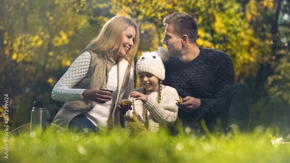 Fototapeta premium Joyful family having fun in autumn park, spending leisure time together, happy