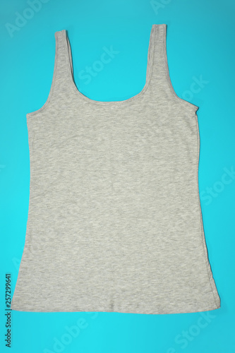 Gray sleeveless female casual tank top on blue background. Sport, fitness aparrel. Basic look. photo