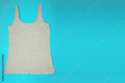 Gray sleeveless female casual tank top on blue background. Copyspace. Sport, fitness aparrel. Basic look. photo