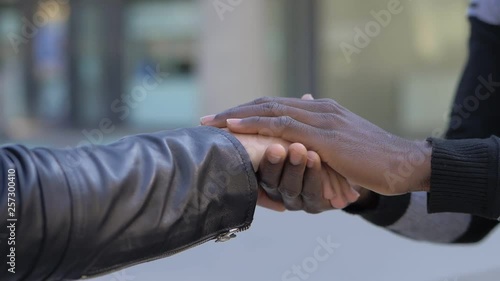 love, friendship between races concept. Black man hands holding white woman hand photo