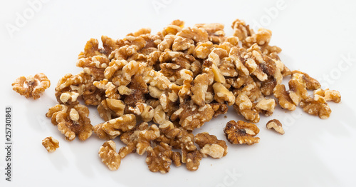 Pile of shelled walnuts on white surface