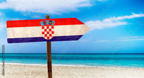 Croatia flag on wooden table sign on beach background. It is summer sign of Croatia.