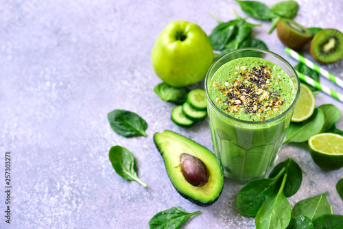 Detox green smoothie with green vegetables, oats and seeds in a tall glass.Top view with copy space.