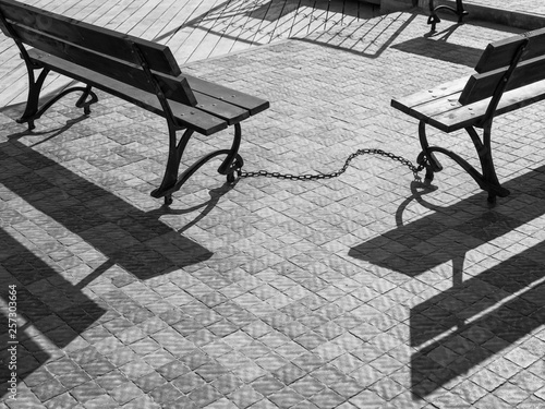 Wallpaper Mural black and white photo in retro style of two wooden benches that united metal chain with shadows Torontodigital.ca