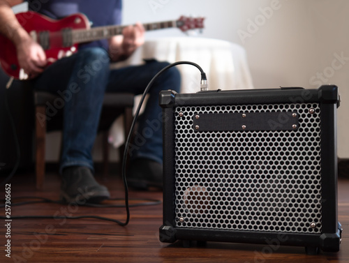 Obraz na płótnie Guitar amplifier close up with man playing guitar in the the background. w salonie