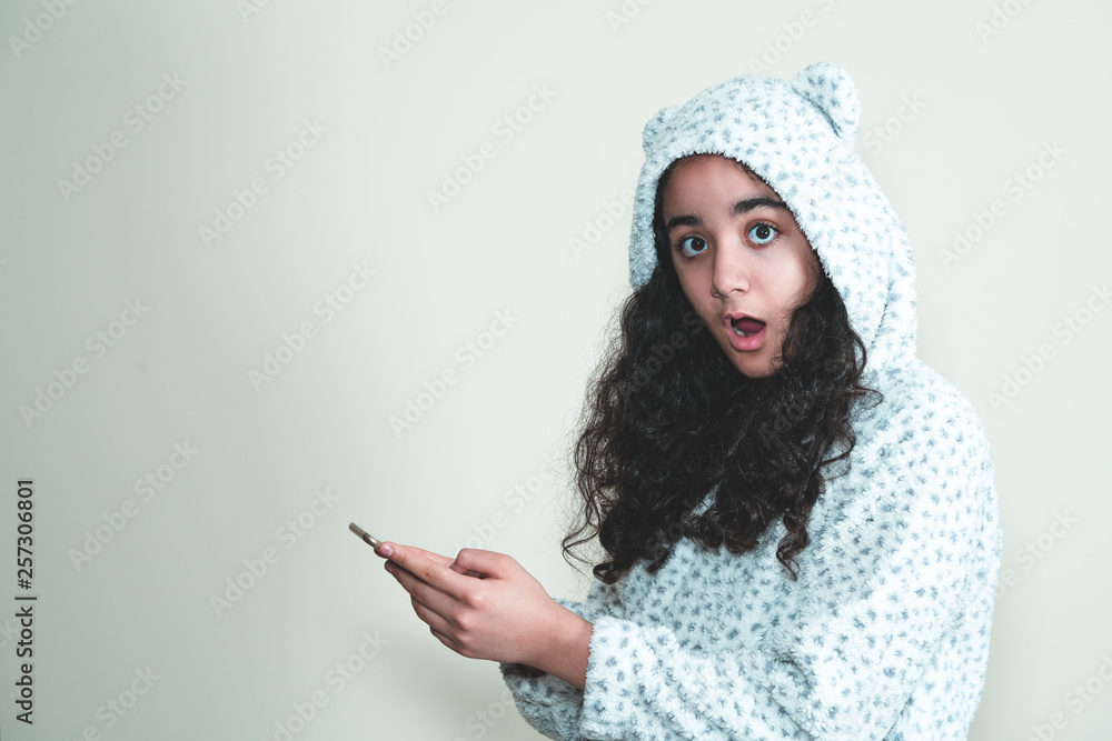 girl in hoodie looking at her mobile phone girl in hoodie looking at her mobile phone