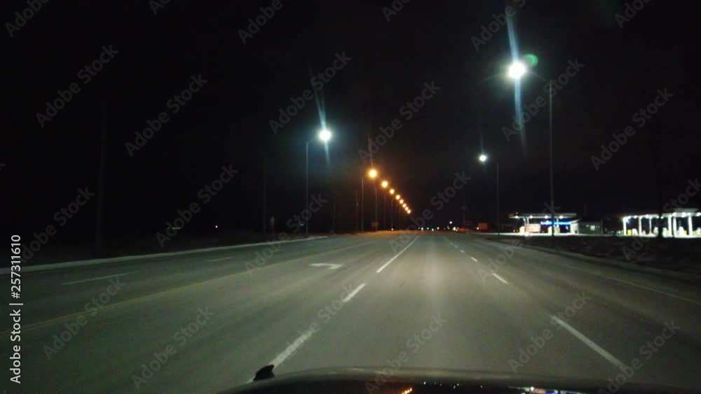 Driving Cruising Down An Empty Highway At Night Passing A Gas Station With Overhead Street Lamps Driving Cruising Down An Empty Highway At Night Passing A Gas Station With Overhead Street Lamps
