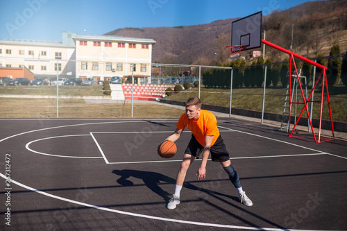 Young basketball player on training on street court © Novak