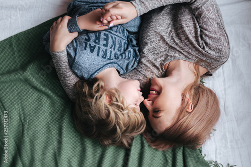 Fotografie Beautiful woman and her cute little son are touching their noses and smiling