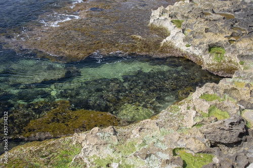 Clear transparent green water and limestone rocks closeup