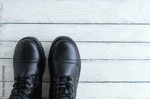 Black leather shoes with laces on a white wooden background. View from above. Close-up.