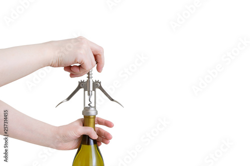 Caucasian girls hand opens a bottle of wine with a corkscrew. White isolate photo