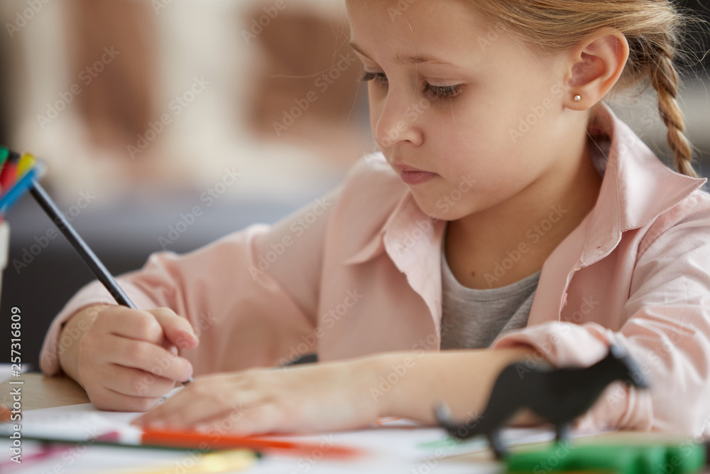 Head and shoulders portrait of cute little girl drawing pictures sitting at table at pre-school, copy space Head and shoulders portrait of cute little girl drawing pictures sitting at table at pre-school, copy space