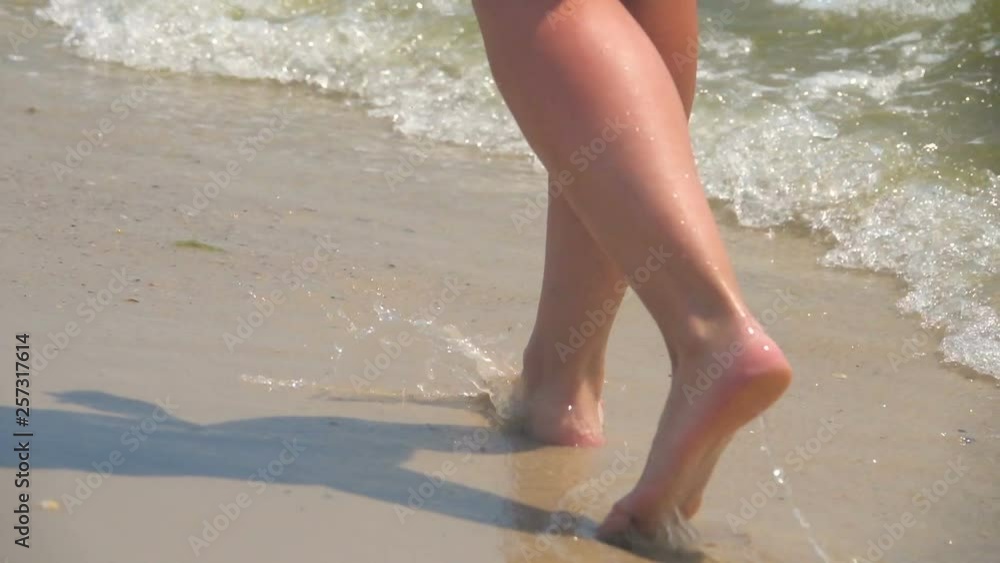 A girl walks along the sandy seashore. Slow Motion A girl walks along the sandy seashore. Slow Motion