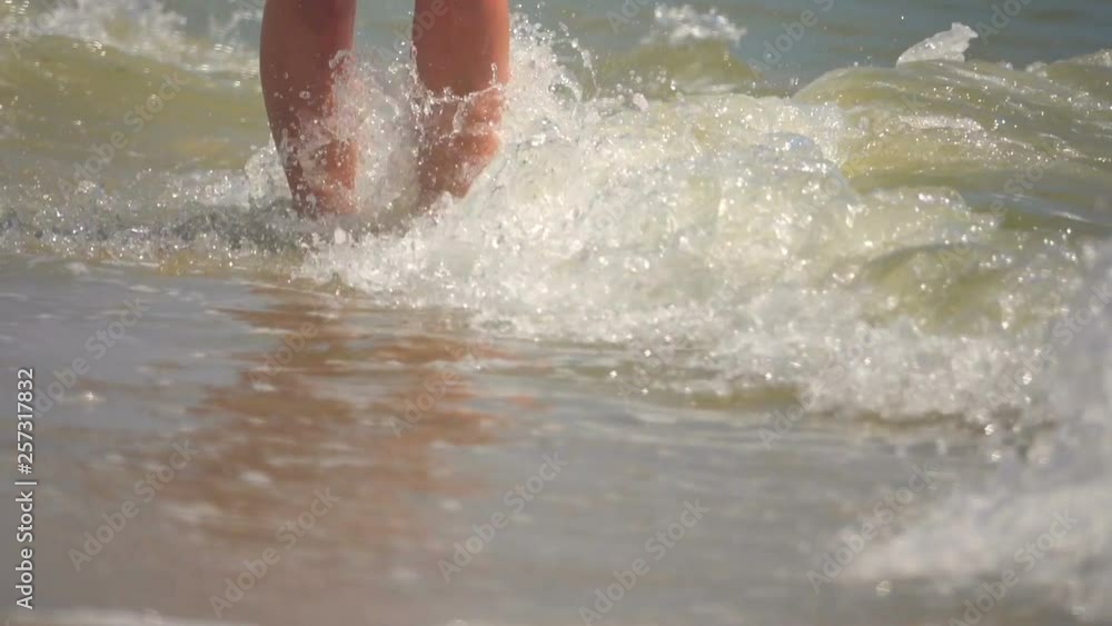 A girl walks along the sandy seashore. Slow Motion A girl walks along the sandy seashore. Slow Motion