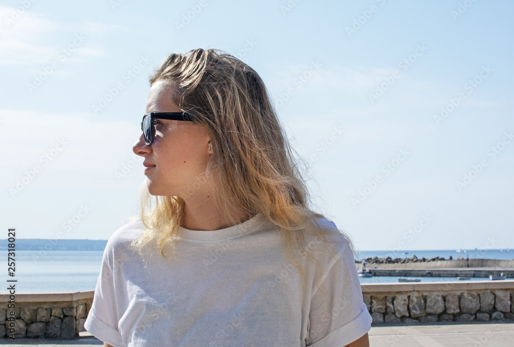 Young casual sporty dressed blonde woman with sunglasses