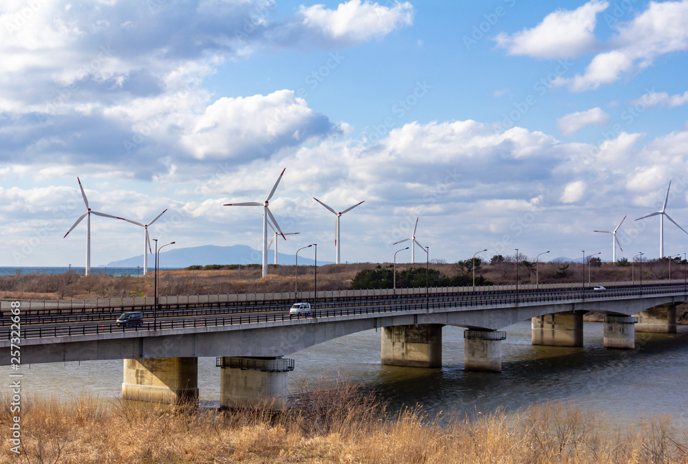 風力発電と道路を走行する自動車　自然エネルギー　イメージ