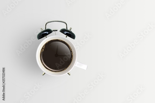 Coffee Break Concept : Retro black alarm clock with coffee cup.