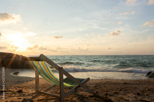Summer vacation deckchairs on tropical beach and ocean sea at sunrise background. Travel and vacation holiday. photo