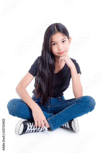 Full length of asian girl sitting and smiles on floor over white background