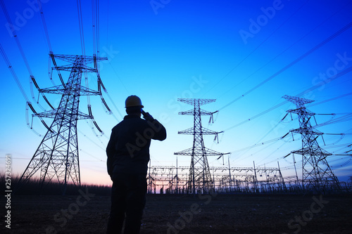 electricity workers and pylon silhouette