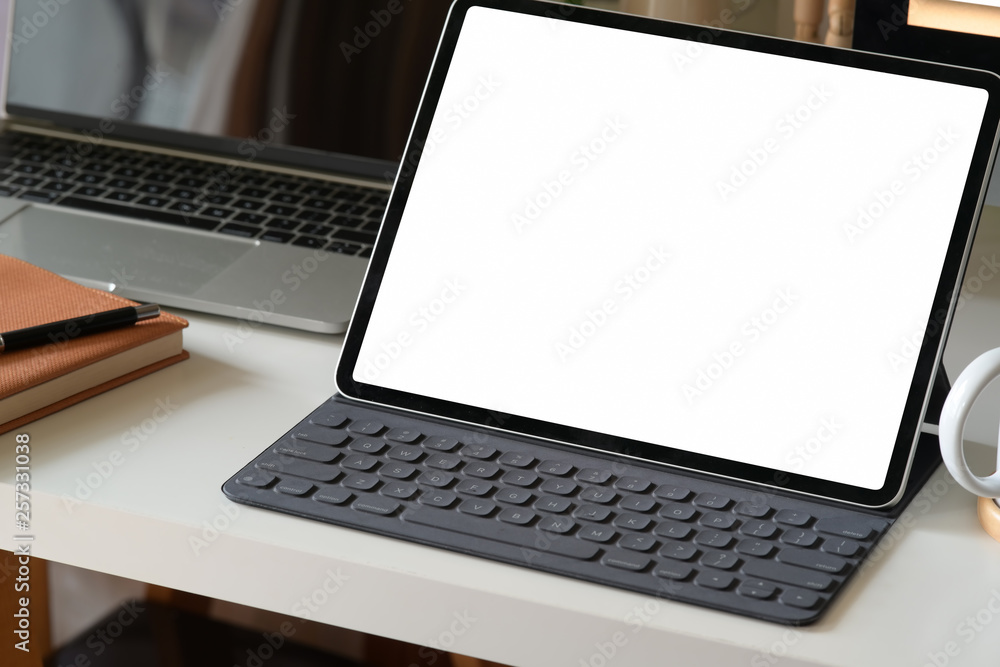 Mock up modern digital tablet on workspace Mock up modern digital tablet on workspace