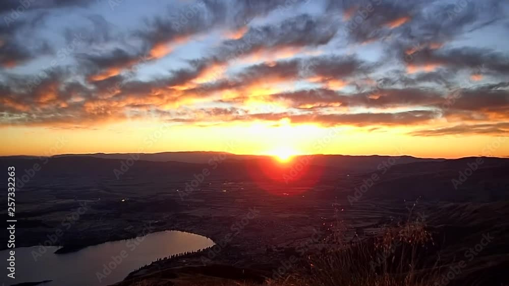 beautiful sunrise with warm colors and clouds on top of Roy's peak above lake Wanaka, in New Zealand beautiful sunrise with warm colors and clouds on top of Roy's peak above lake Wanaka, in New Zealand