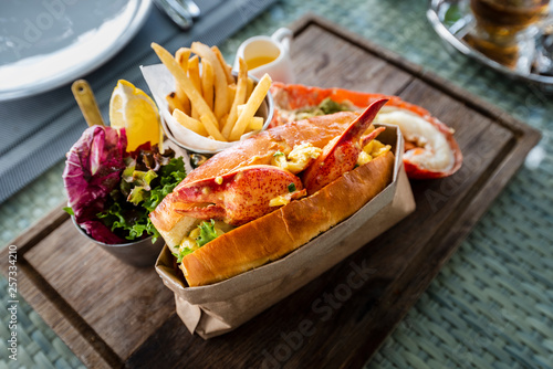 Delicious lobster roll sandwich Served with a side of French Fries and fresh salad. New England lobster roll © Theerawat
