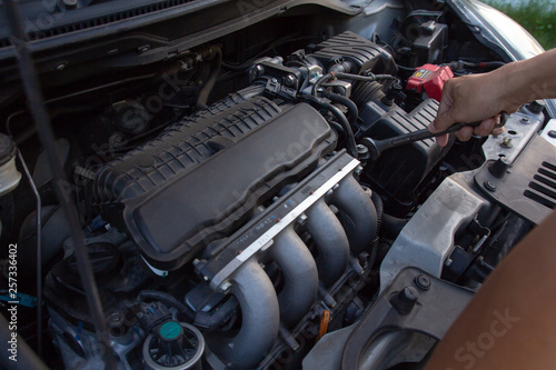 Mechanic, technician man holding spanner checking car engine. car service, repair, fixing, checking maintenance working at auto repair garage workshop. inspection vehicle concept.