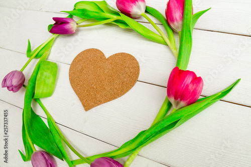 Beautiful red and pink tulips on white background with space for text and congratulations. Top view, flat lay.