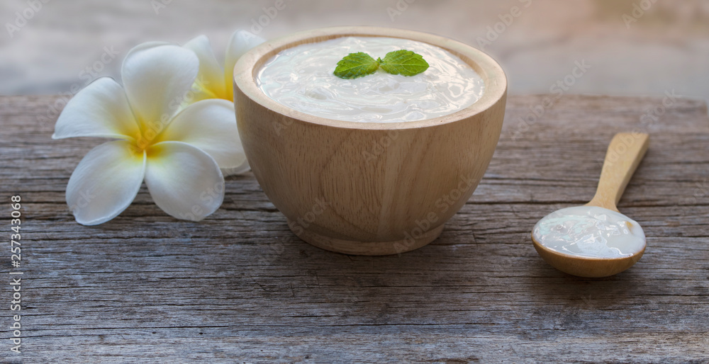 The yogurt is in a wooden cup, placed in an old wooden floor. The yogurt is in a wooden cup, placed in an old wooden floor.