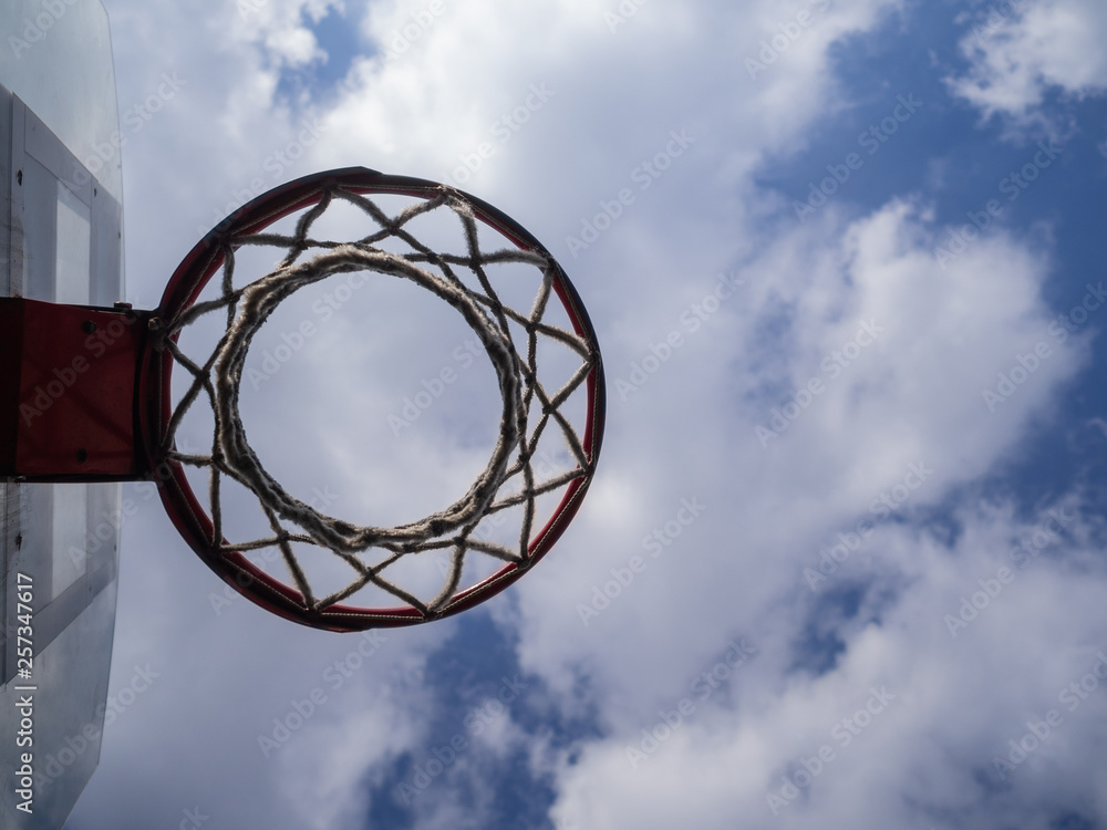 Basketball ring against the background of the blue sky with clouds. Sports ground Basketball ring against the background of the blue sky with clouds. Sports ground