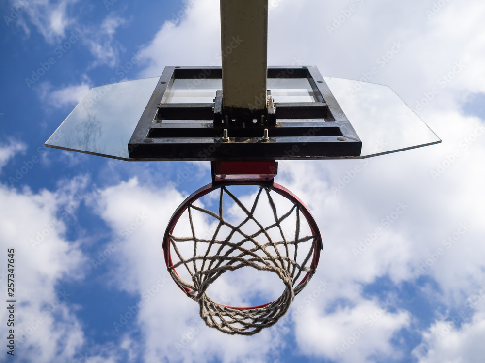 Basketball ring against the background of the blue sky with clouds. Sports ground Basketball ring against the background of the blue sky with clouds. Sports ground