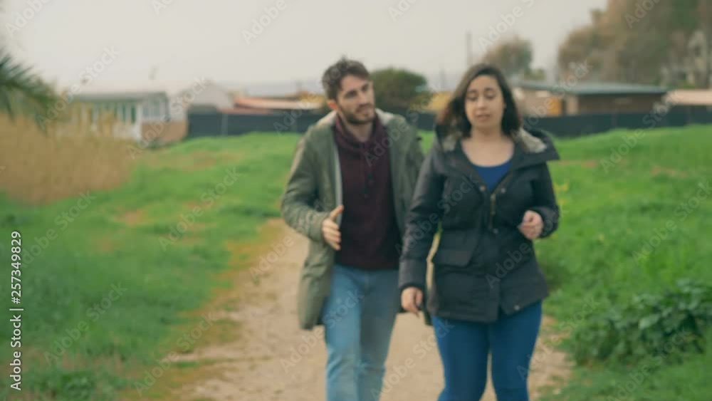 Defocused young lovers arguing violently in the park.Crisis,betrayal,break up Defocused young lovers arguing violently in the park.Crisis,betrayal,break up