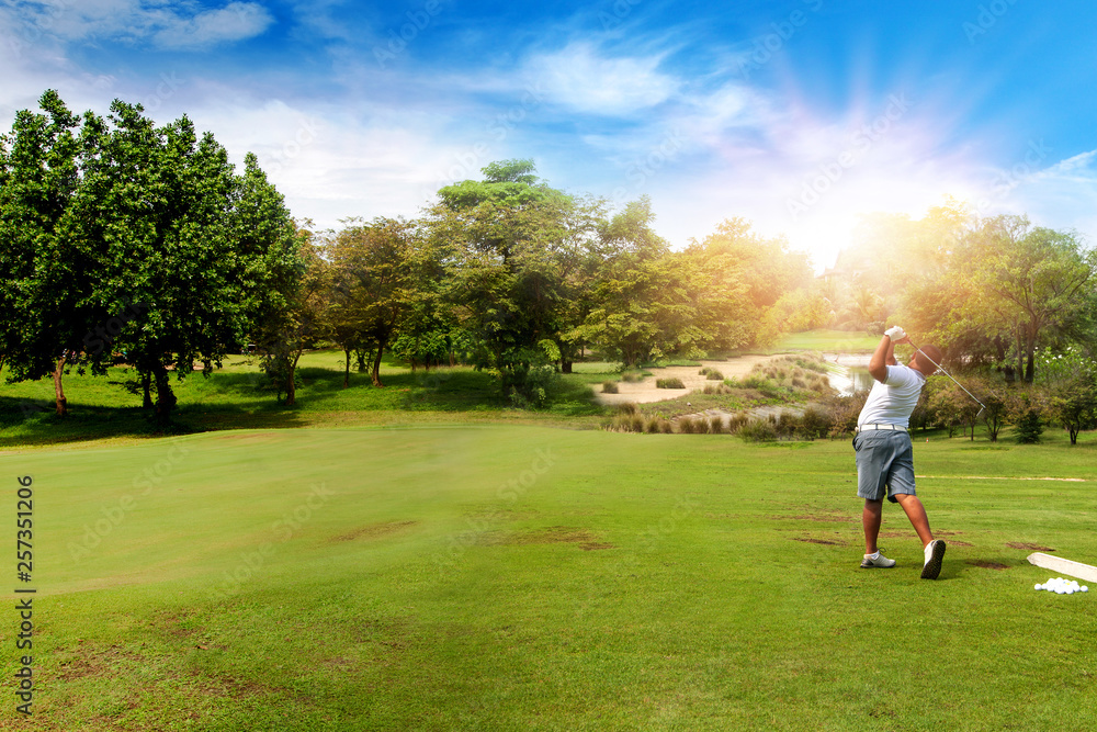 Panorama of Golfer hit sweeping golf ball on blurred beautiful golf course with sunshine on background.	