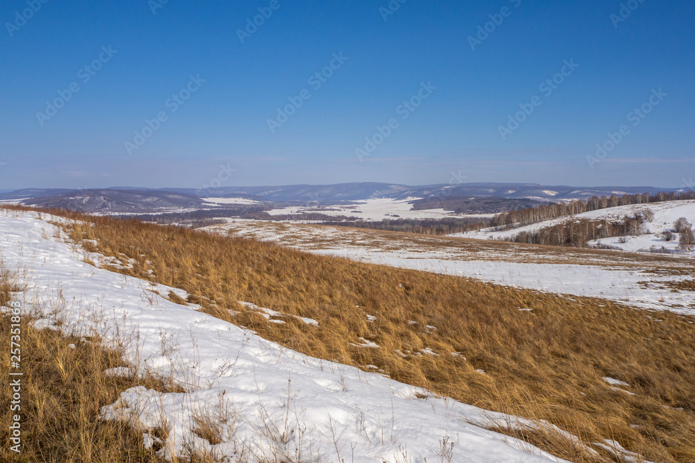 Spring landscape. Hills covered with melting snow.