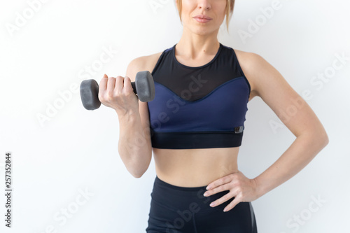 Healthy lifestyle, people and sport concept - Athletic woman doing exercise for arms close up